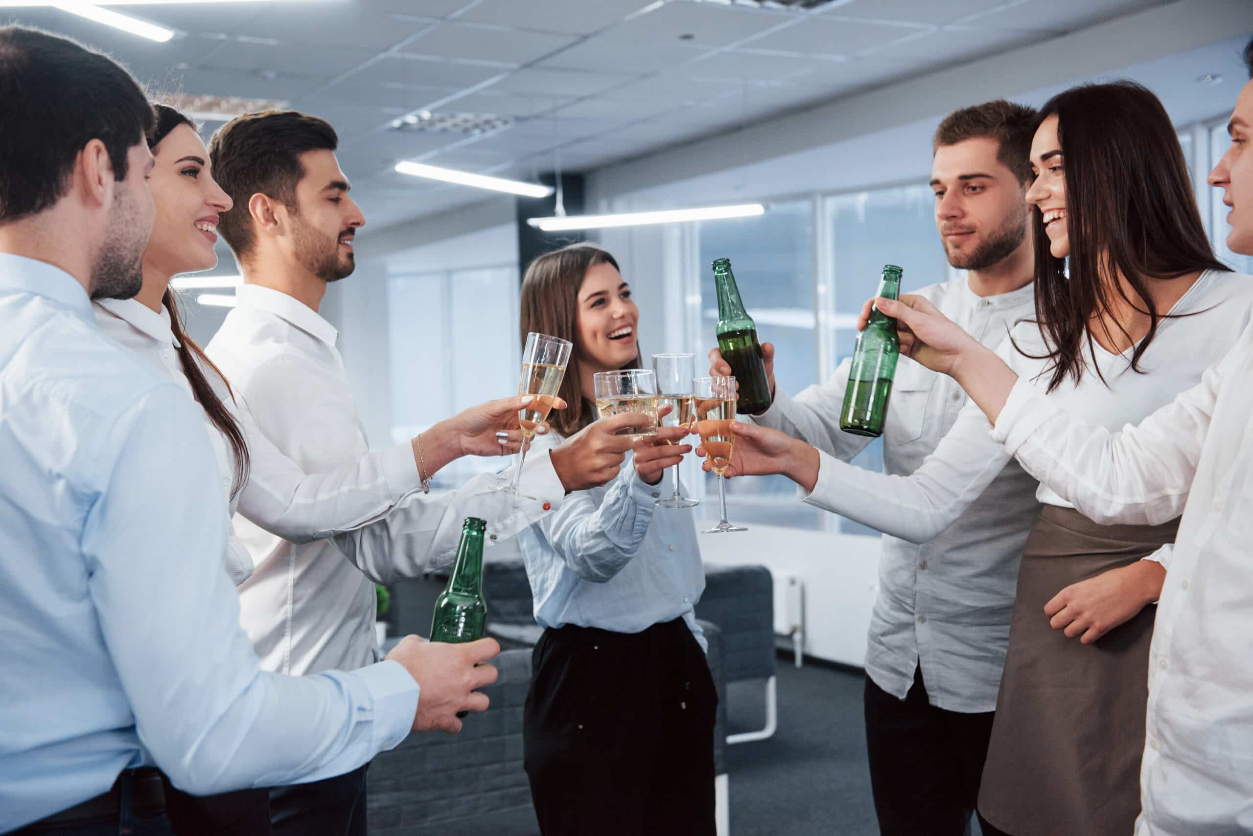 Sincere smiles. Standing and knocking the bottles and glass. In the office